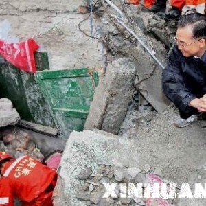 温家宝冒雨攀上瓦砾堆摔倒手臂出血